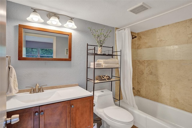 full bathroom featuring a textured ceiling, shower / bath combo, vanity, and toilet