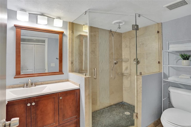 bathroom with vanity, a textured ceiling, toilet, and an enclosed shower