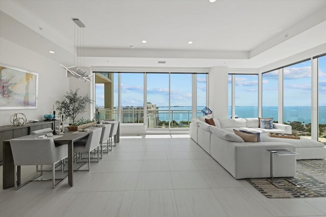 living room featuring plenty of natural light, a water view, and light tile patterned floors