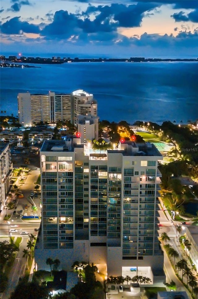 aerial view at dusk featuring a water view