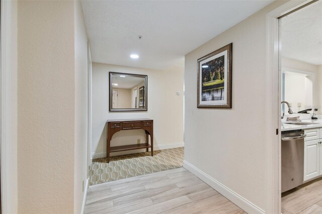 hallway with sink and light hardwood / wood-style flooring