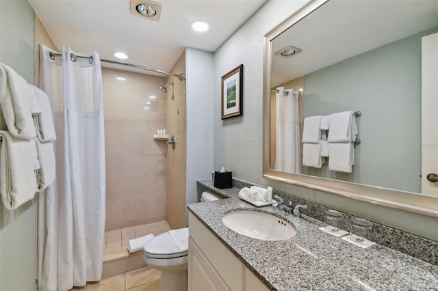 bathroom featuring tile patterned floors, vanity, curtained shower, and toilet