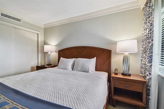 bedroom featuring crown molding, a textured ceiling, and a closet