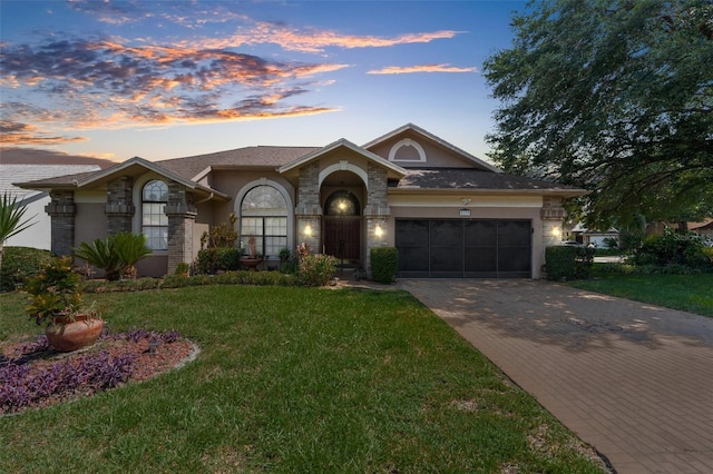 single story home featuring a garage and a yard