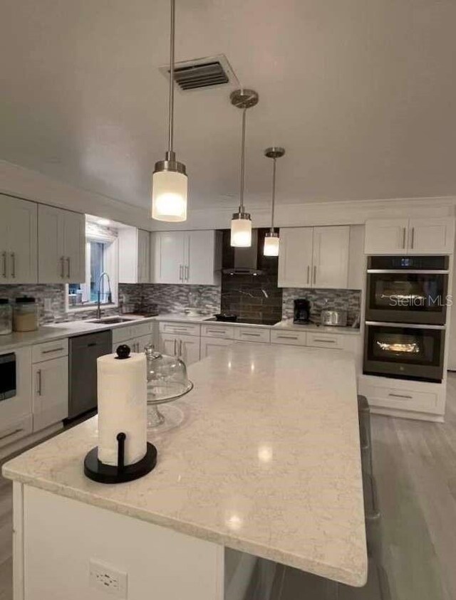 kitchen with black appliances, a kitchen island, and sink