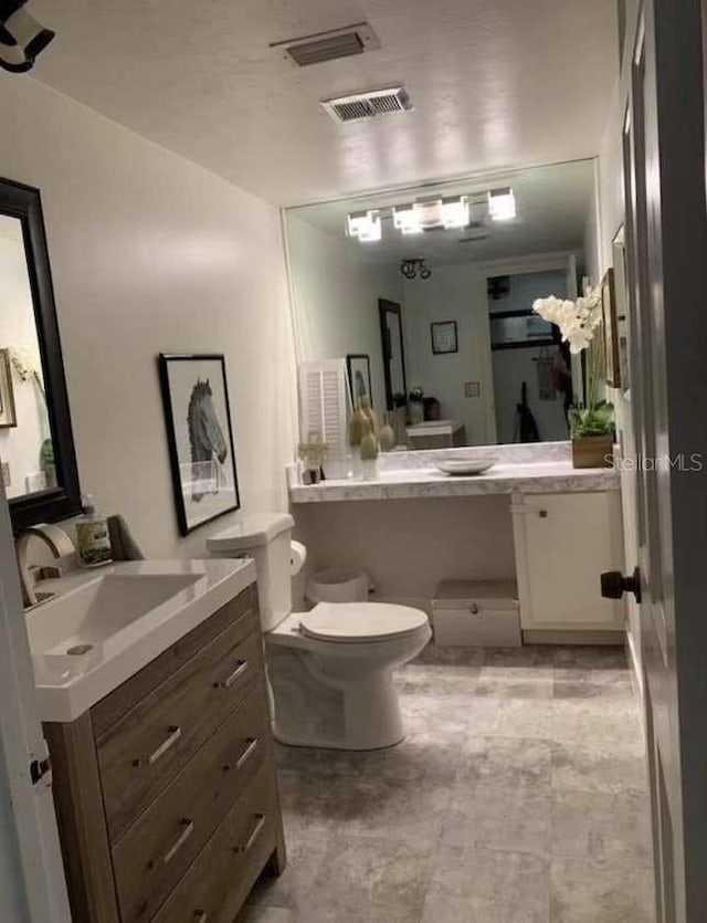 bathroom featuring tile patterned floors, vanity, and toilet