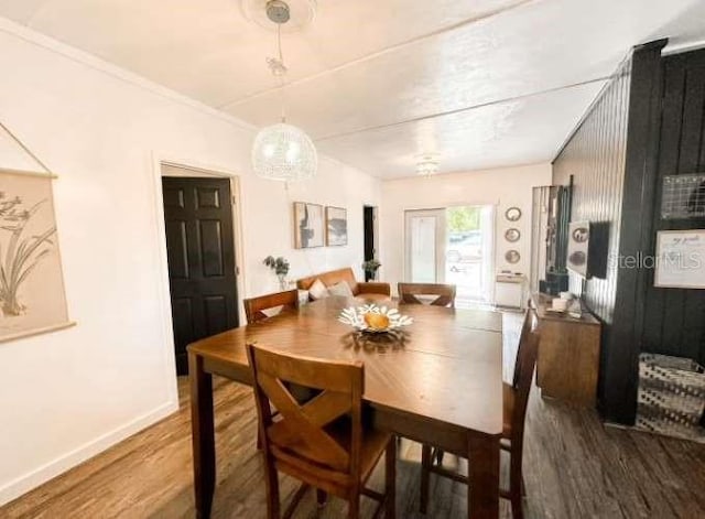 dining area with wood-type flooring and crown molding