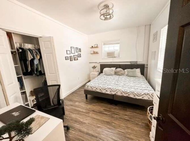 bedroom with a closet, crown molding, and hardwood / wood-style floors