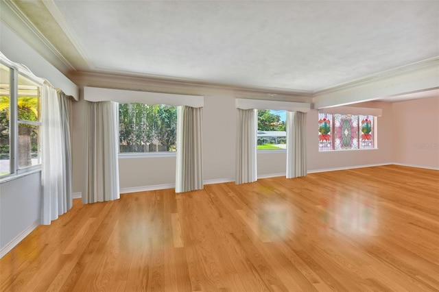 unfurnished room with ornamental molding, a healthy amount of sunlight, and light wood-type flooring