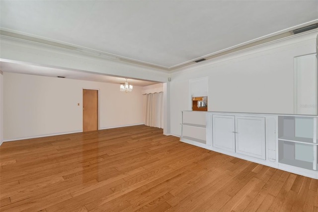 unfurnished room with crown molding, a notable chandelier, and light hardwood / wood-style flooring