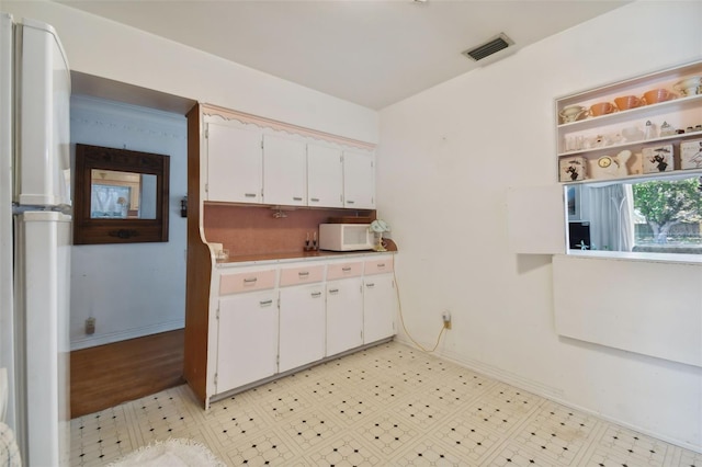 kitchen featuring white cabinets and white appliances