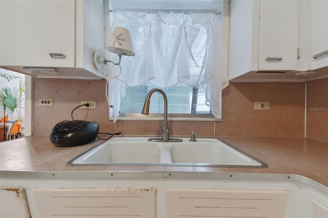 kitchen with sink, decorative backsplash, and white cabinets