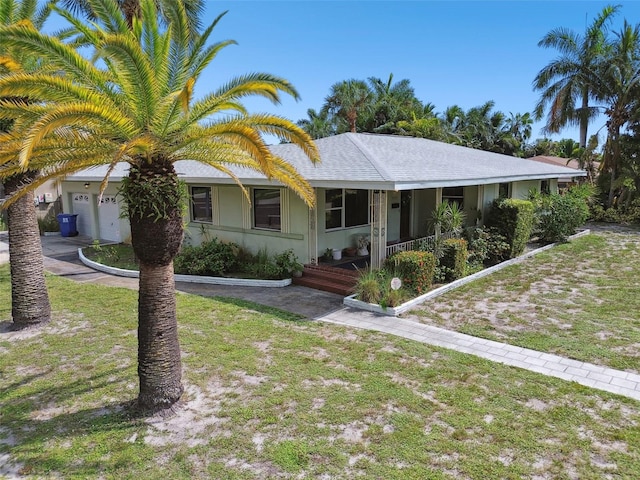 ranch-style home featuring a garage, covered porch, and a front lawn