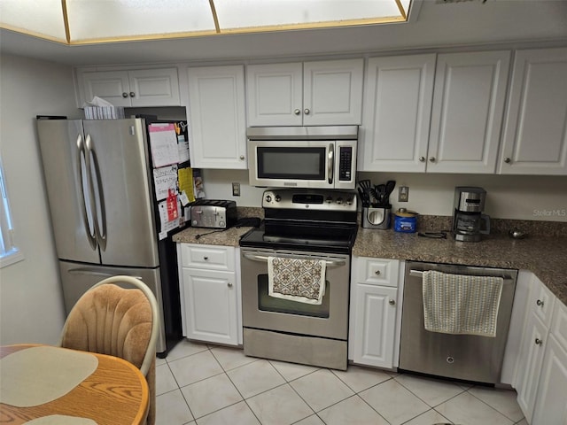 kitchen featuring light tile patterned floors, white cabinets, and stainless steel appliances