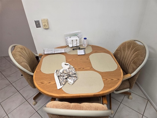 dining space featuring baseboards and light tile patterned flooring