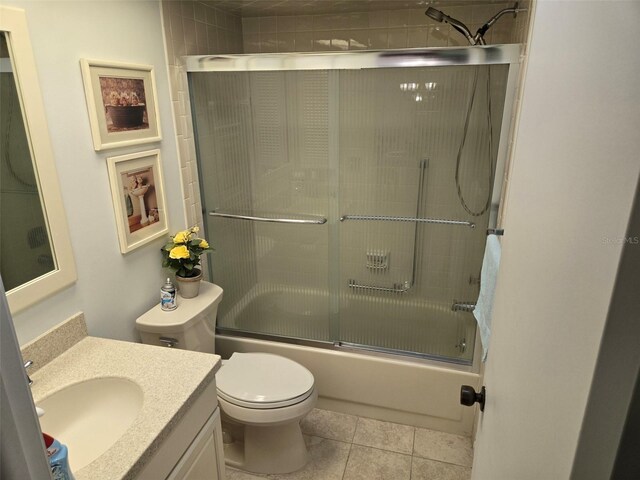 full bathroom featuring shower / bath combination with glass door, vanity, tile patterned flooring, and toilet