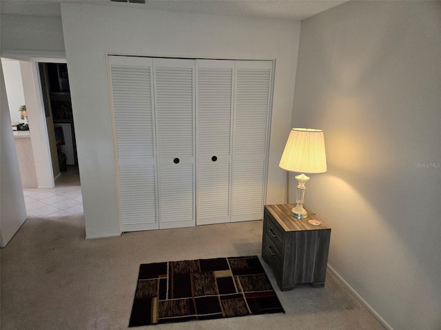 interior space featuring light carpet, baseboards, and light tile patterned flooring