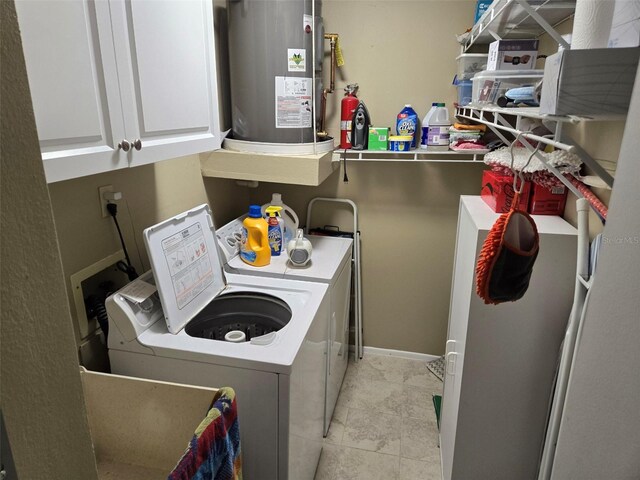 washroom with water heater, cabinets, washer and dryer, and light tile patterned floors