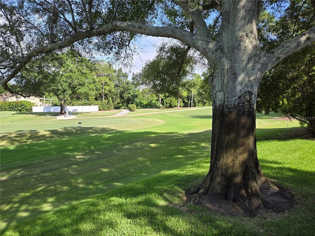 surrounding community with view of golf course and a lawn