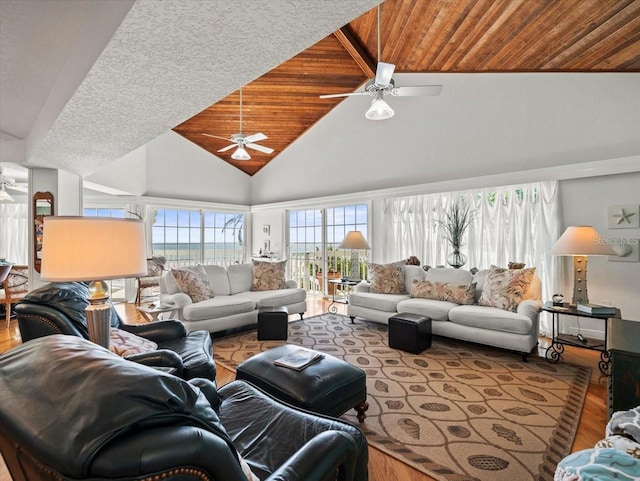 living room featuring hardwood / wood-style flooring, wooden ceiling, ceiling fan, and high vaulted ceiling