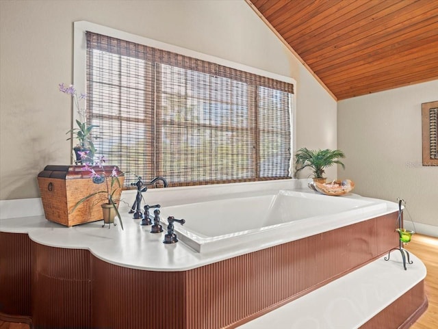 bathroom featuring lofted ceiling, hardwood / wood-style flooring, and a bathtub