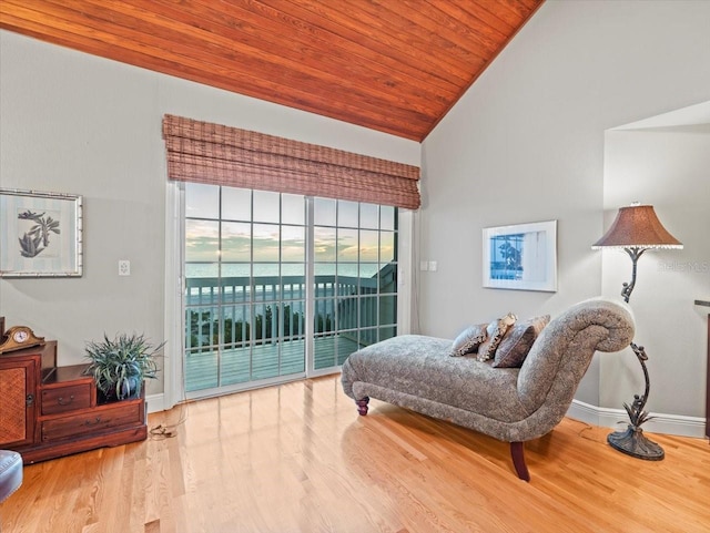 living area featuring light hardwood / wood-style floors, a water view, wood ceiling, and high vaulted ceiling