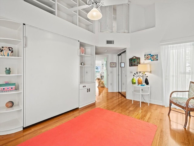 interior space with a high ceiling and light wood-type flooring