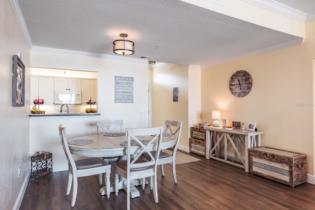 dining room with dark hardwood / wood-style floors, ornamental molding, and a textured ceiling