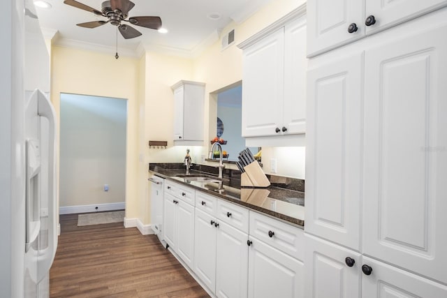 kitchen with dark stone counters, ceiling fan, sink, white refrigerator with ice dispenser, and white cabinets