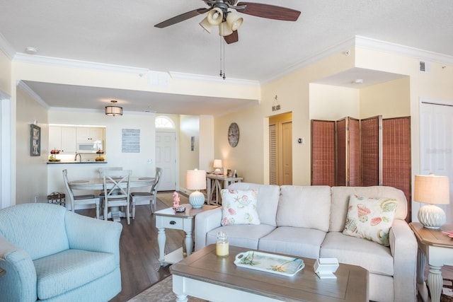 living room with dark hardwood / wood-style floors, ceiling fan, and crown molding