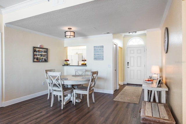 dining area with a textured ceiling, crown molding, and dark wood-type flooring