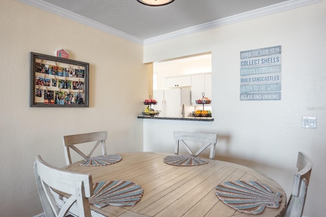 dining area featuring ornamental molding and a textured ceiling