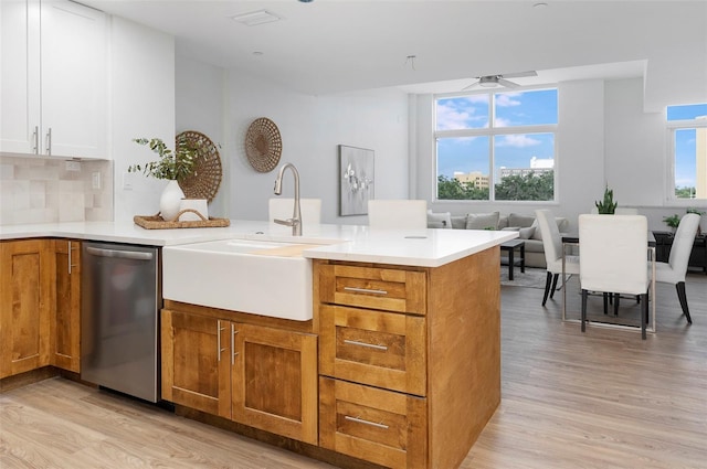 kitchen with plenty of natural light, dishwasher, light wood-type flooring, and white cabinetry