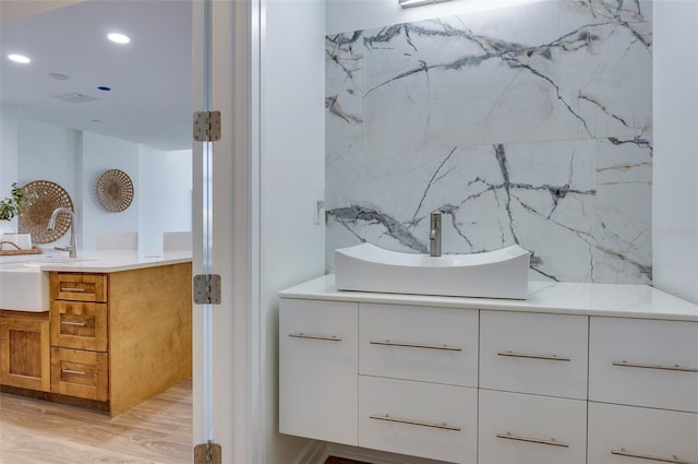 bathroom with tile walls, hardwood / wood-style flooring, and double sink vanity