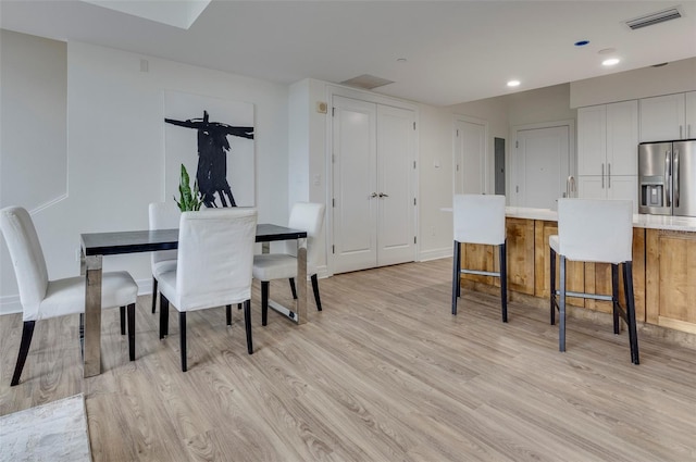 dining space with light hardwood / wood-style flooring