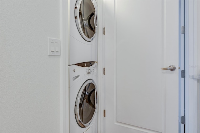 clothes washing area with stacked washer and clothes dryer