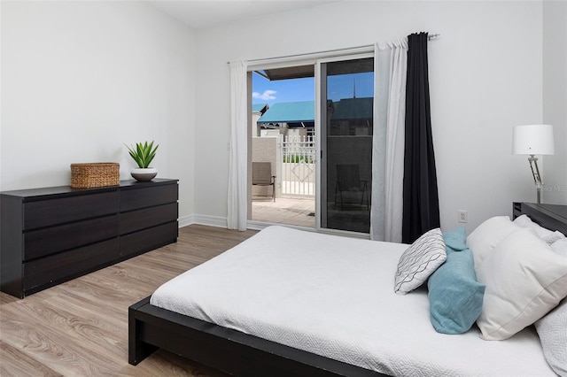 bedroom with light wood-type flooring and access to exterior