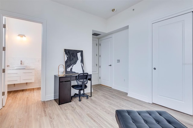 office area with sink and light wood-type flooring