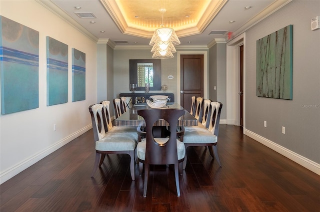 dining space featuring crown molding, hardwood / wood-style floors, and a tray ceiling