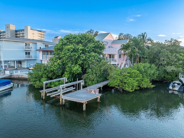 view of dock with a balcony and a water view