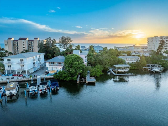 aerial view at dusk featuring a water view