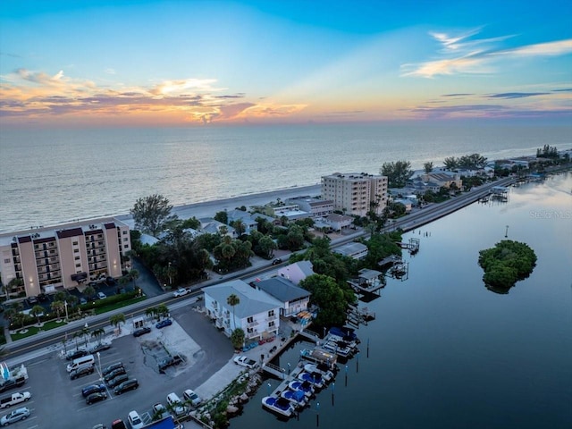 aerial view at dusk featuring a water view