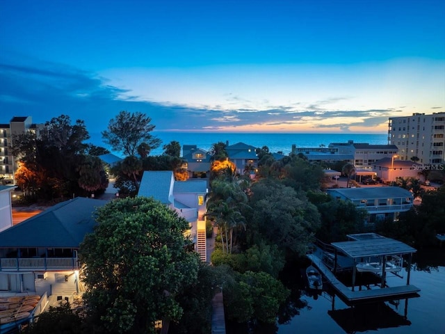 aerial view at dusk featuring a water view