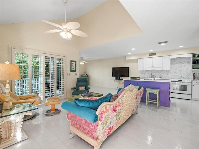 living room featuring ceiling fan, vaulted ceiling, and light tile patterned floors