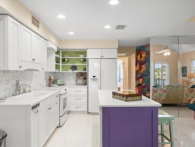 kitchen with white cabinetry, ceiling fan, and white appliances