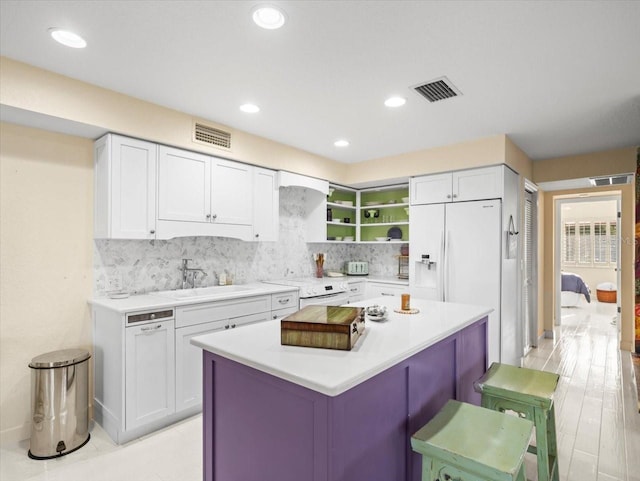 kitchen with tasteful backsplash and white cabinets