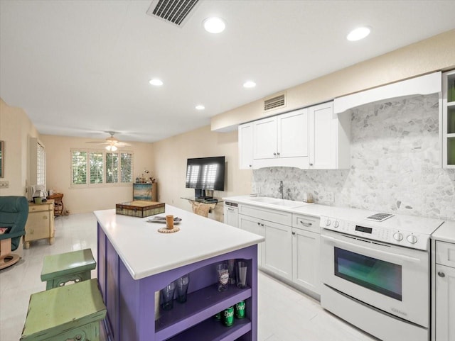 kitchen featuring white electric range oven, white cabinets, ceiling fan, decorative backsplash, and sink