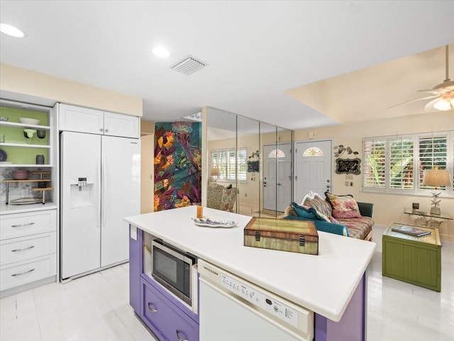 kitchen with plenty of natural light, white cabinetry, ceiling fan, and white appliances