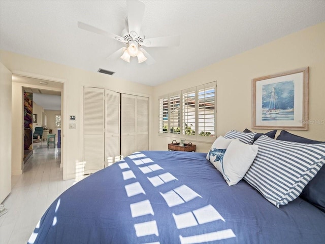 bedroom with wood-type flooring, a closet, and ceiling fan