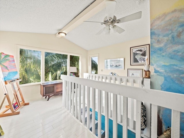 corridor featuring a textured ceiling, lofted ceiling, and plenty of natural light